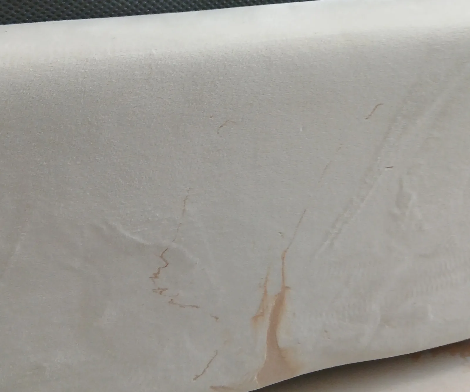 Makeup foundation stain on an upholstered bed base, Before